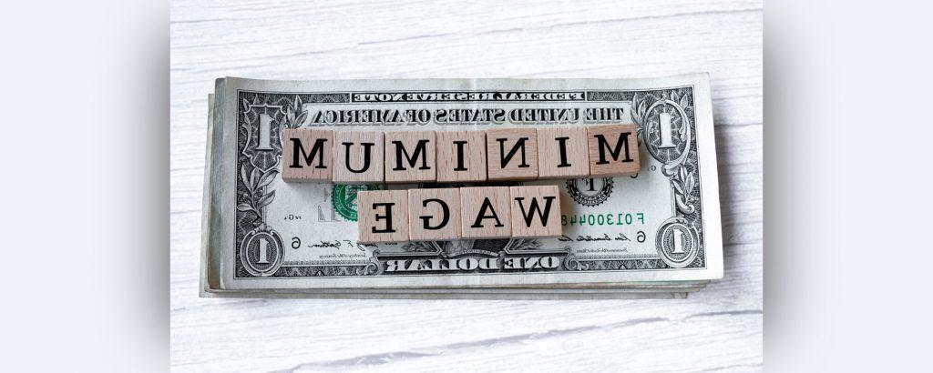 一张一美元的钞票放在桌子上，上面写着最低工资